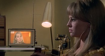 Movie still from “Fahrenheit 451” (1966), directed by François Truffaut – A woman sitting in front of a television in front of a phone; Close Up shot, High angle