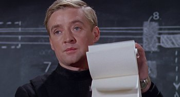 Movie still from “Fahrenheit 451” (1966), directed by François Truffaut – A man holding a roll of toilet paper in front of a blackboard; Close Up shot, Low angle