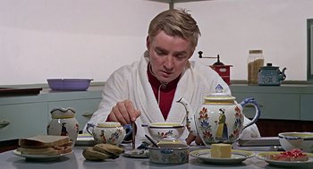 Movie still from “Fahrenheit 451” (1966), directed by François Truffaut – A man sitting at a table with a cup of tea; Medium shot, Low angle