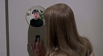 Movie still from “Fahrenheit 451” (1966), directed by François Truffaut – A woman looking in a mirror while holding a cell phone; Close Up shot, Overhead angle
