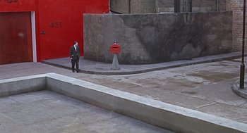 Movie still from “Fahrenheit 451” (1966), directed by François Truffaut – A man standing next to a mailbox on a sidewalk; Extreme Wide shot, High angle