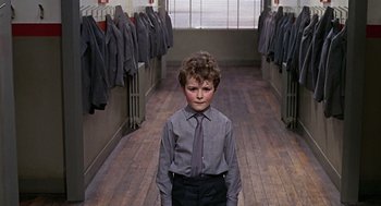 Movie still from “Fahrenheit 451” (1966), directed by François Truffaut – A young boy in a dress shirt and tie in a hallway; Wide shot, Low angle