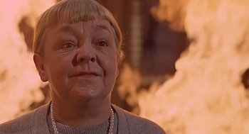 Movie still from “Fahrenheit 451” (1966), directed by François Truffaut – An older woman is smiling in front of a fire; Close Up shot, Low angle