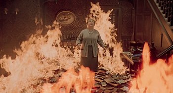 Movie still from “Fahrenheit 451” (1966), directed by François Truffaut – An old woman standing in front of a fire; Wide shot, High angle