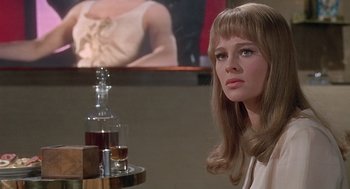 Movie still from “Fahrenheit 451” (1966), directed by François Truffaut – A woman sitting at a table with a glass of whiskey; Close Up shot, Over the shoulder angle