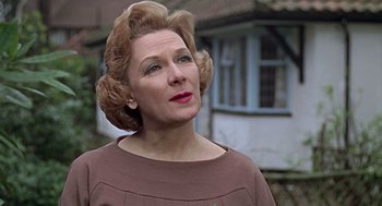 Movie still from “Fahrenheit 451” (1966), directed by François Truffaut – An older woman wearing a brown dress and a pair of big buns; Close Up shot, Low angle