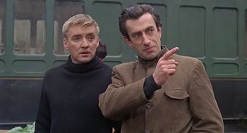 Movie still from “Fahrenheit 451” (1966), directed by François Truffaut – Two men standing next to each other in front of a building; Close Up shot, Low angle