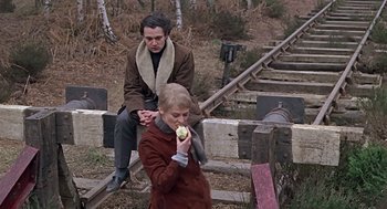 Movie still from “Fahrenheit 451” (1966), directed by François Truffaut – A man and a woman eating an apple on a bridge; Medium shot, High angle