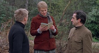 Movie still from “Fahrenheit 451” (1966), directed by François Truffaut – A woman reading a book to two men outside; Medium shot, Over the shoulder angle
