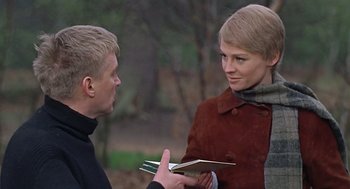 Movie still from “Fahrenheit 451” (1966), directed by François Truffaut – A man and a woman are holding a book in their hands; Close Up shot, Over the shoulder angle