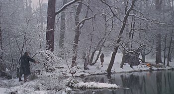 Movie still from “Fahrenheit 451” (1966), directed by François Truffaut – A person standing in the snow next to a body of water; Extreme Wide shot, High angle