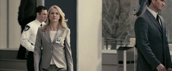 Movie still from “Fair Game” (2010), directed by Doug Liman – A woman wearing a suit and tie walking outside; Medium shot, Low angle