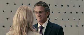 Movie still from “Fair Game” (2010), directed by Doug Liman – A man wearing a suit and tie talking to a woman; Close Up shot, Over the shoulder angle