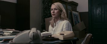 Movie still from “Fair Game” (2010), directed by Doug Liman – A woman sitting at a table with a phone; Medium shot, Over the shoulder angle