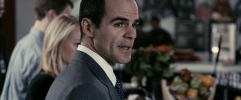 Movie still from “Fair Game” (2010), directed by Doug Liman – A person wearing a suit and tie; Close Up shot, Over the shoulder angle