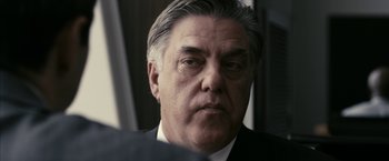 Movie still from “Fair Game” (2010), directed by Doug Liman – An older man wearing a suit and tie; Close Up shot, Over the shoulder angle