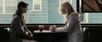 Movie still from “Fair Game” (2010), directed by Doug Liman – A woman sitting at a table with a cup of coffee; Medium shot, Over the shoulder angle