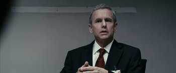 Movie still from “Fair Game” (2010), directed by Doug Liman – An older man in a suit and red tie; Close Up shot, Over the shoulder angle