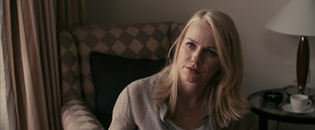Movie still from “Fair Game” (2010), directed by Doug Liman – A woman sitting on a couch looking at the camera; Close Up shot, Over the shoulder angle