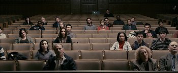 Movie still from “Fair Game” (2010), directed by Doug Liman – A group of people sitting in rows in a theater; Wide shot, High angle