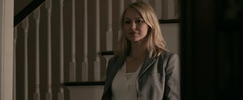 Movie still from “Fair Game” (2010), directed by Doug Liman – A woman in a suit standing in front of a wall; Medium shot, Over the shoulder angle