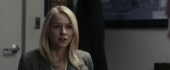 Movie still from “Fair Game” (2010), directed by Doug Liman – A woman with blonde hair and a gray suit jacket; Close Up shot, Over the shoulder angle