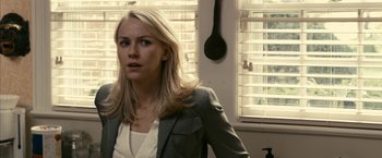 Movie still from “Fair Game” (2010), directed by Doug Liman – A woman in a gray jacket is sitting in front of a window; Close Up shot, Over the shoulder angle