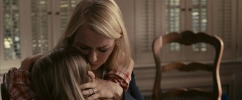 Movie still from “Fair Game” (2010), directed by Doug Liman – A woman hugging another woman in a living room; Close Up shot, Over the shoulder angle