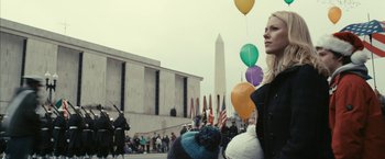 Movie still from “Fair Game” (2010), directed by Doug Liman – A woman standing next to balloons in front of a crowd; Medium shot, Low angle