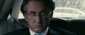 Movie still from “Fair Game” (2010), directed by Doug Liman – An older man wearing glasses and a suit and tie; Close Up shot, Over the shoulder angle