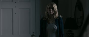 Movie still from “Fair Game” (2010), directed by Doug Liman – A woman standing in front of a door in a dark room; Close Up shot, Over the shoulder angle