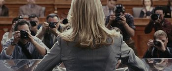 Movie still from “Fair Game” (2010), directed by Doug Liman – A woman in a gray jacket is taking a picture; Medium shot, Over the shoulder angle