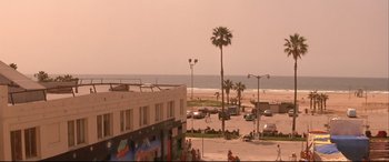 Movie still from “Falling Down” (1993), directed by Joel Schumacher – People are sitting on the sidewalk near the ocean; Extreme Wide shot, High angle