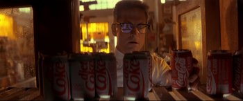 Movie still from “Falling Down” (1993), directed by Joel Schumacher – A man sitting in front of a row of diet coke cans; Close Up shot, Low angle