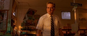 Movie still from “Falling Down” (1993), directed by Joel Schumacher – A man wearing a tie and glasses standing in a room; Medium shot, Low angle