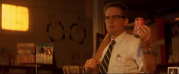 A man holding a large wooden stick in a room