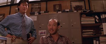 Movie still from “Falling Down” (1993), directed by Joel Schumacher – A man with a beard is standing in front of lockers; Medium shot, Low angle