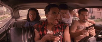 Movie still from “Falling Down” (1993), directed by Joel Schumacher – A group of people riding in a car with a gun; Close Up shot, Low angle
