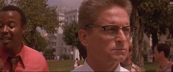 Movie still from “Falling Down” (1993), directed by Joel Schumacher – A person wearing glasses with a building in the background; Close Up shot, Low angle