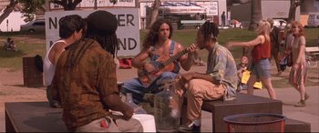 Movie still from “Falling Down” (1993), directed by Joel Schumacher – A group of men sitting on a bench playing guitars; Medium shot, Low angle