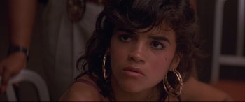 Movie still from “Falling Down” (1993), directed by Joel Schumacher – A young woman wearing large gold hoop earrings; Close Up shot, Over the shoulder angle