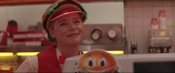 Movie still from “Falling Down” (1993), directed by Joel Schumacher – A woman wearing a hat and holding a paper plate; Close Up shot, Low angle