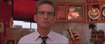 Movie still from “Falling Down” (1993), directed by Joel Schumacher – A man holding a hot dog while wearing glasses; Close Up shot, Low angle
