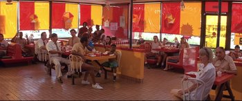 Movie still from “Falling Down” (1993), directed by Joel Schumacher – A group of people sitting at a table in a restaurant; Wide shot, High angle