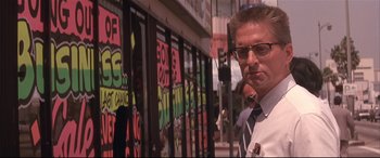 Movie still from “Falling Down” (1993), directed by Joel Schumacher – A man wearing glasses standing in front of a store window; Close Up shot, Low angle