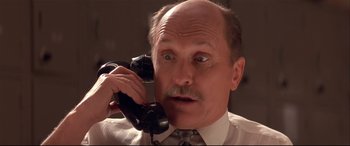 Movie still from “Falling Down” (1993), directed by Joel Schumacher – An older man is holding a phone up to his ear; Close Up shot, Low angle