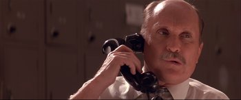 Movie still from “Falling Down” (1993), directed by Joel Schumacher – An older man holding a phone up to his ear; Close Up shot, Low angle