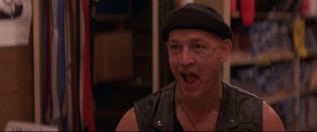 Movie still from “Falling Down” (1993), directed by Joel Schumacher – A person wearing a leather vest; Close Up shot, Low angle