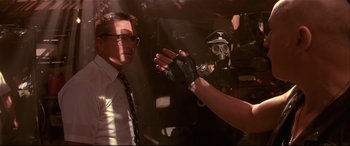 Movie still from “Falling Down” (1993), directed by Joel Schumacher – A man and a woman wearing gloves and a gas mask; Medium shot, Over the shoulder angle