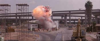 Movie still from “Falling Down” (1993), directed by Joel Schumacher – An explosion on the side of the road near a freeway; Extreme Wide shot, Low angle